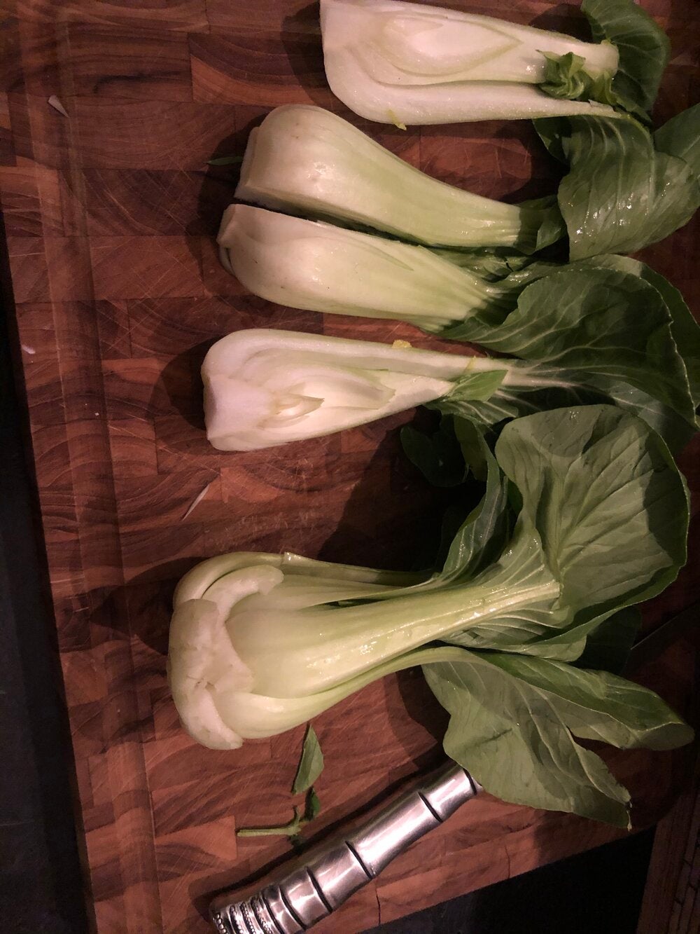 Photo of quartered boy choy on wood cutting board